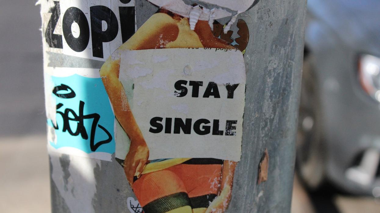 A artistic picture of a woman holding a sign saying, stay single