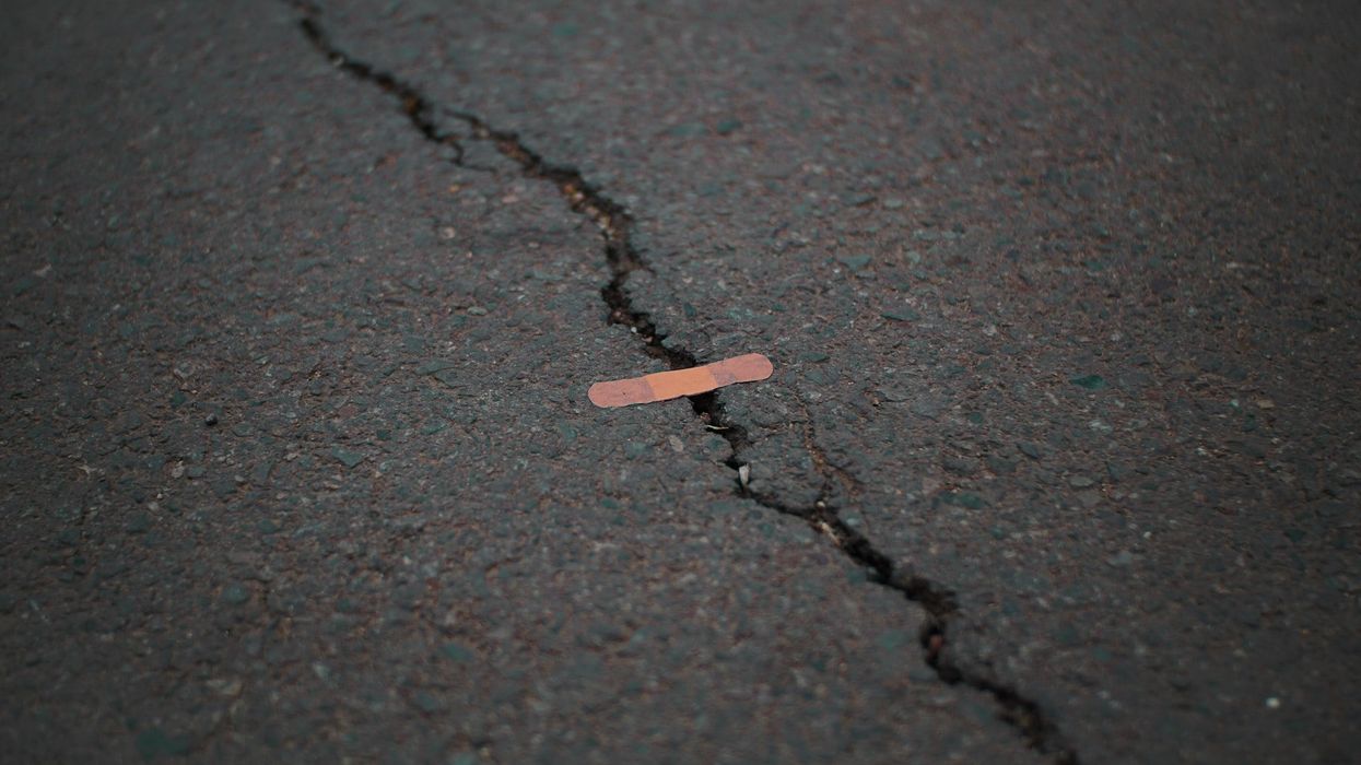 A bandaid is set over a crack in the street
