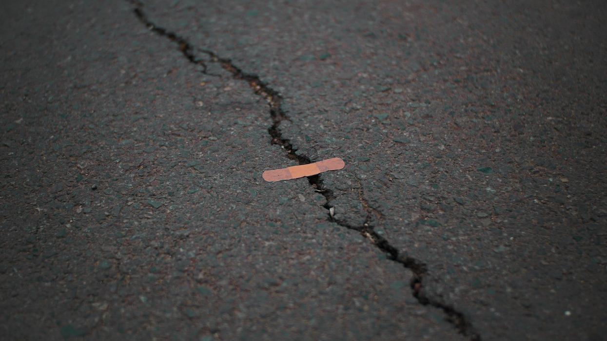 A bandaid is set over a crack in the street
