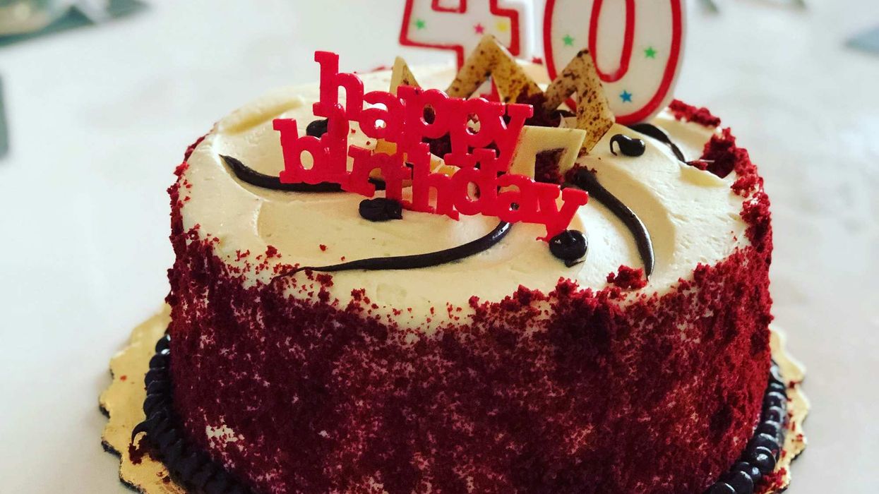 A birthday cake with number 4 and number zero candles on top of it.