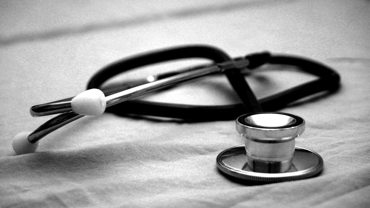 A black and white photo of a stethoscope laying on a sheet.