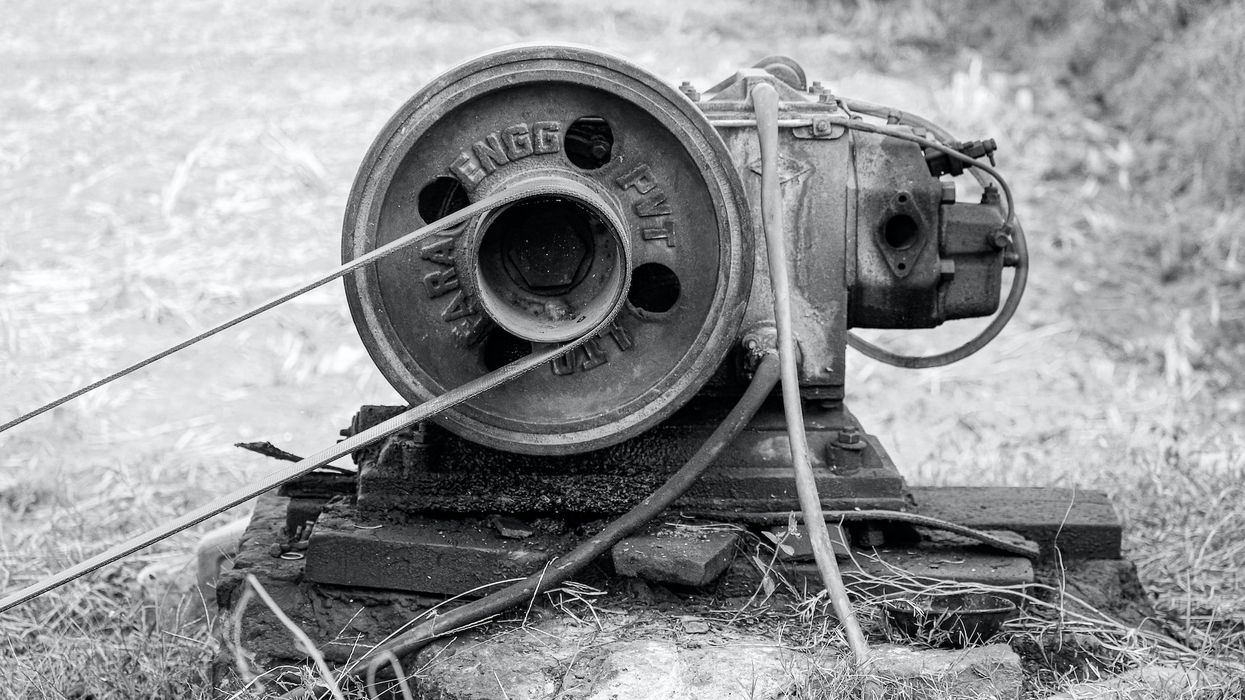 A black and white photo of an Old Motor Engine for pumping water under the earth