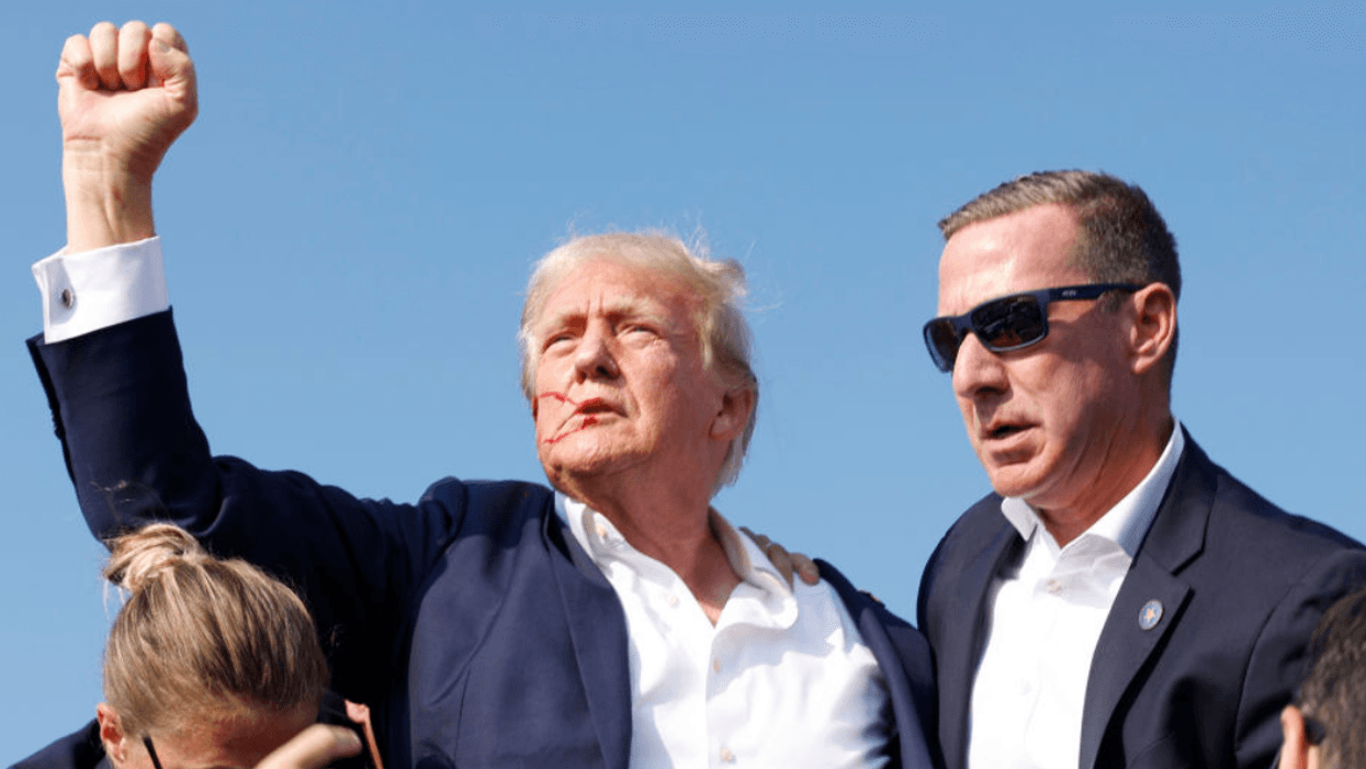 A bloodied Donald Trump raises his fist after surviving an assassination attempt