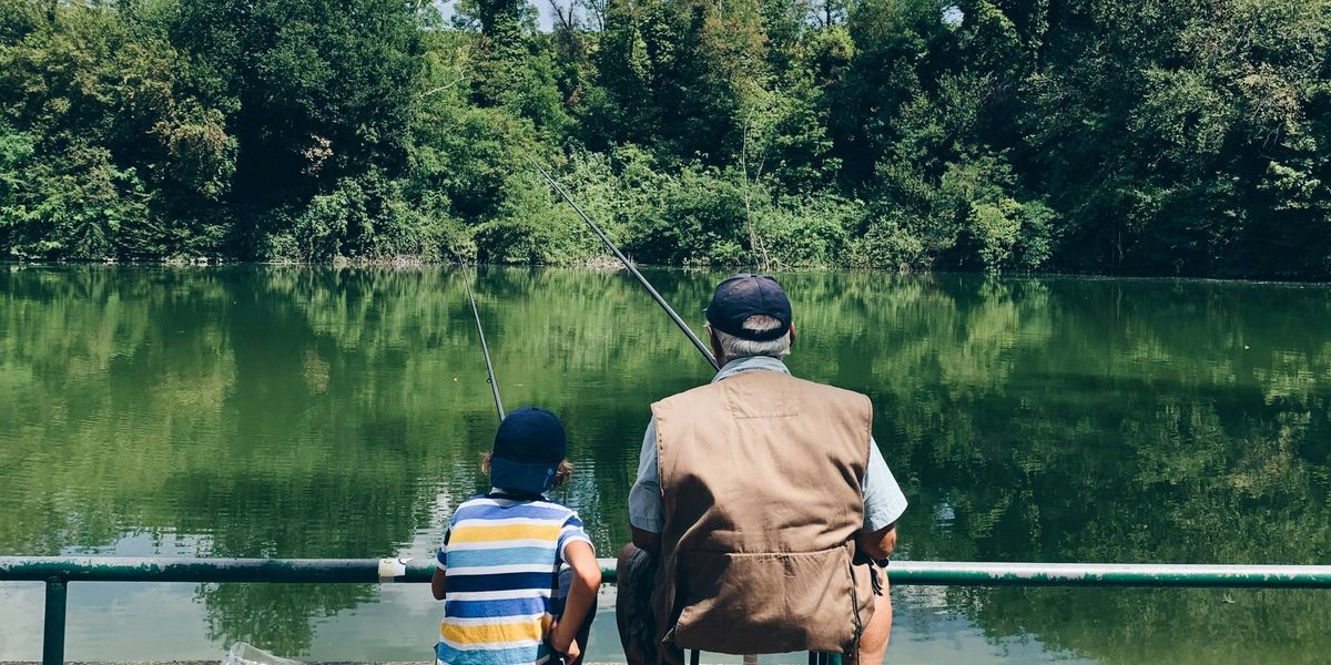 A child and an elderly person fishing together
