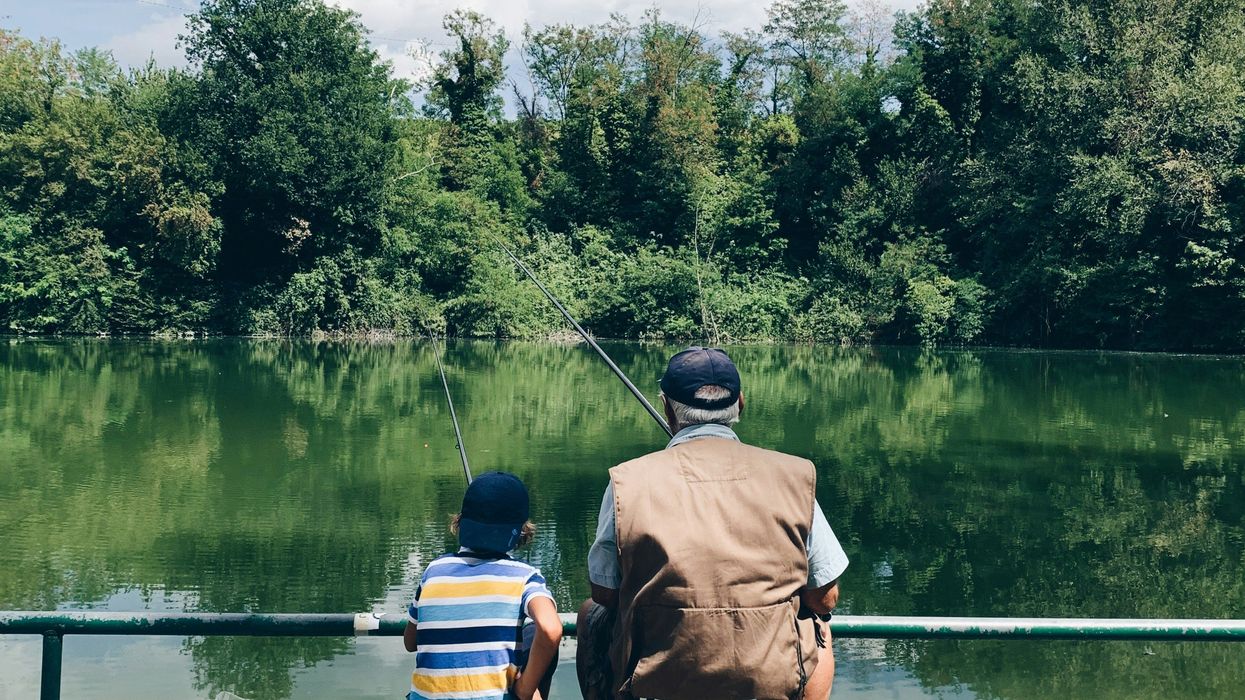 A child and an elderly person fishing together