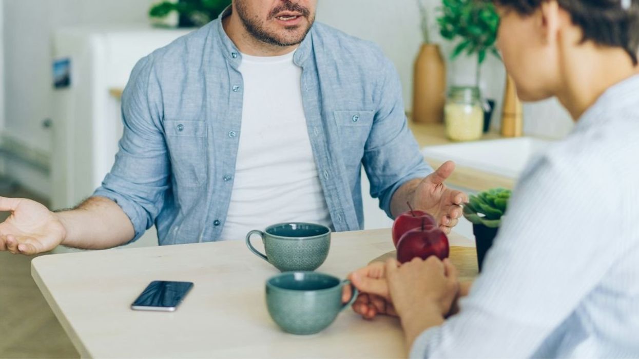 A couple arguing at kitchen table