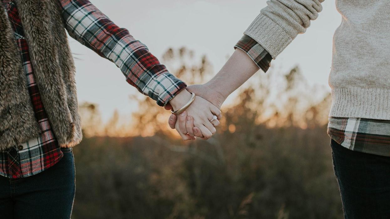 A couple hold hands