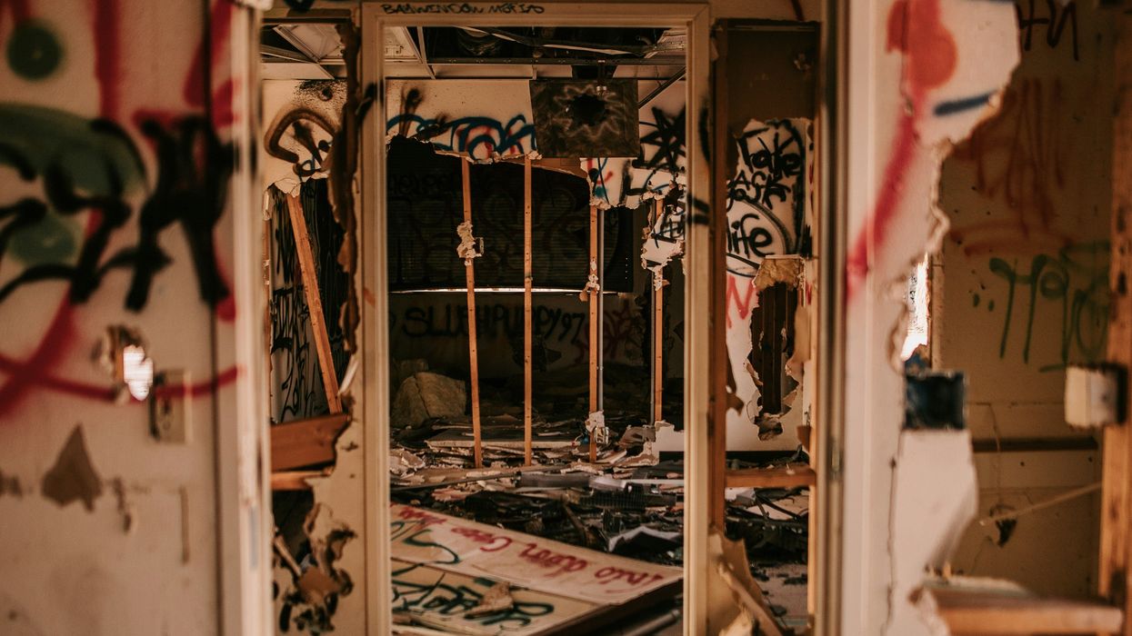 A damaged room covered in grafitti