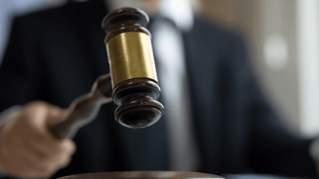 A gavel being struck by a man in a suit