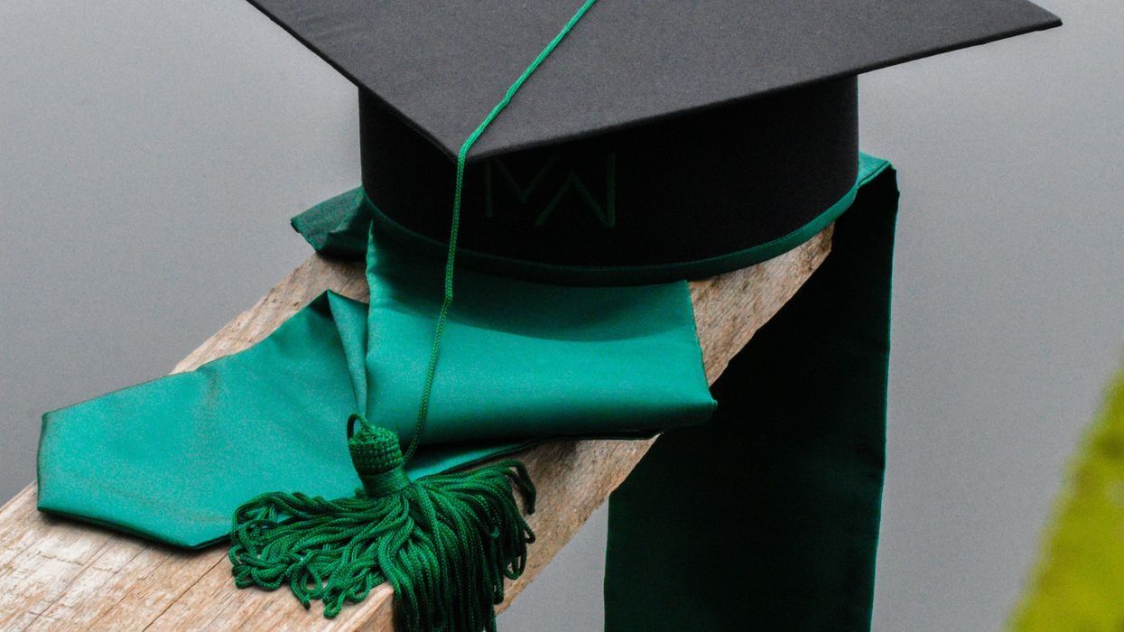 a graduation cap and a green tassel on a piece of wood