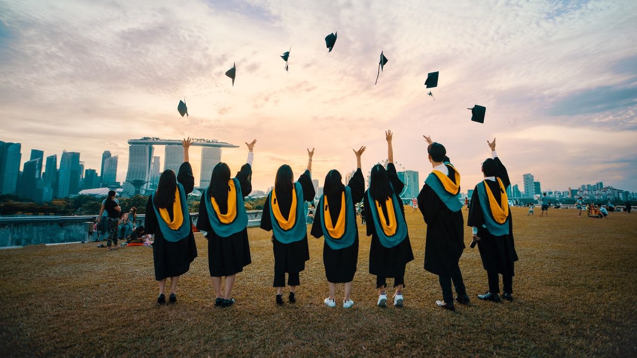 A group of graduating friends throw their caps in the air
