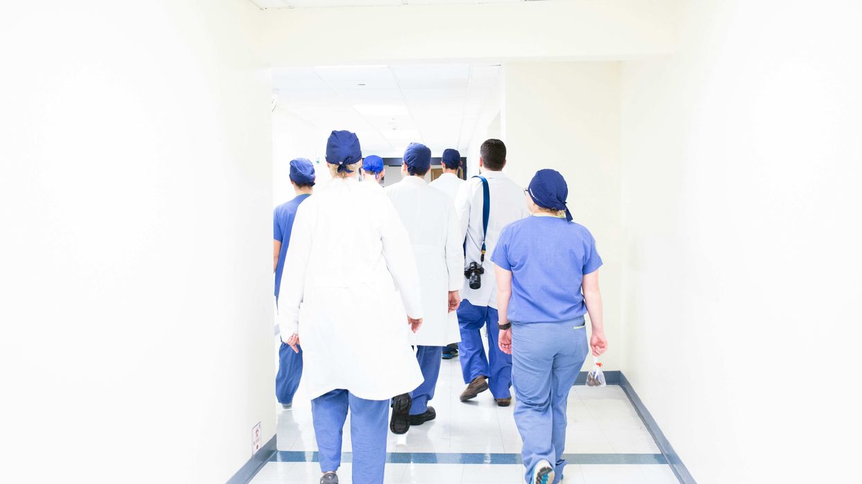 A group of people in medical scrubs walking down a hallway