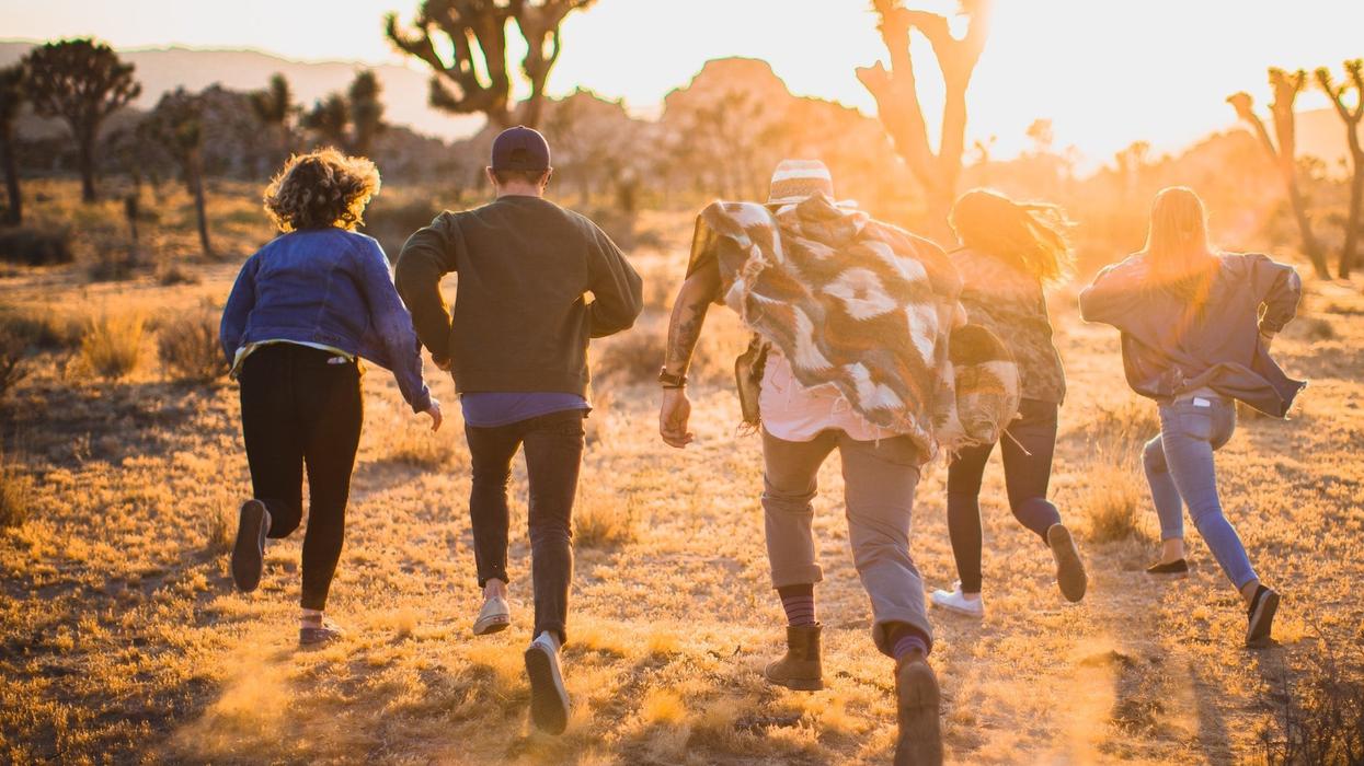 A group of people running through the trees in the desert