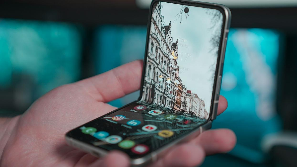 A hand holds an Iphone that can collapse