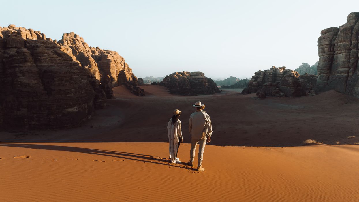 a man and a woman walking in the desert