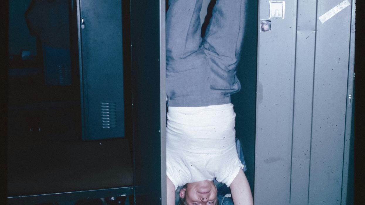 A man hanging upside down in a locker
