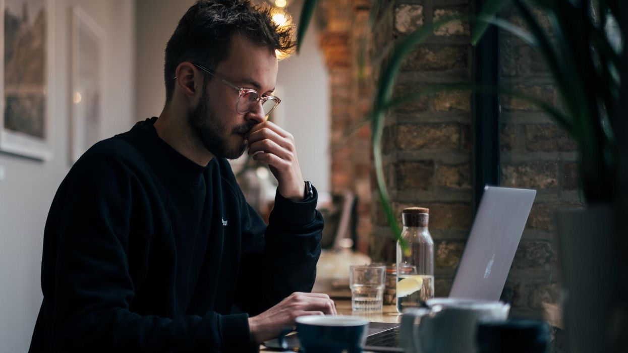 A man looking concerned reads from his laptop