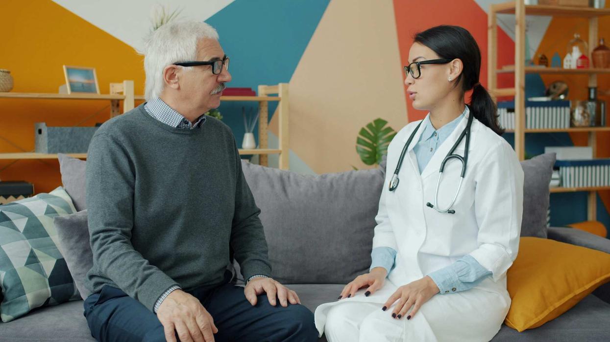 A man sitting on a sofa talking to a female doctor