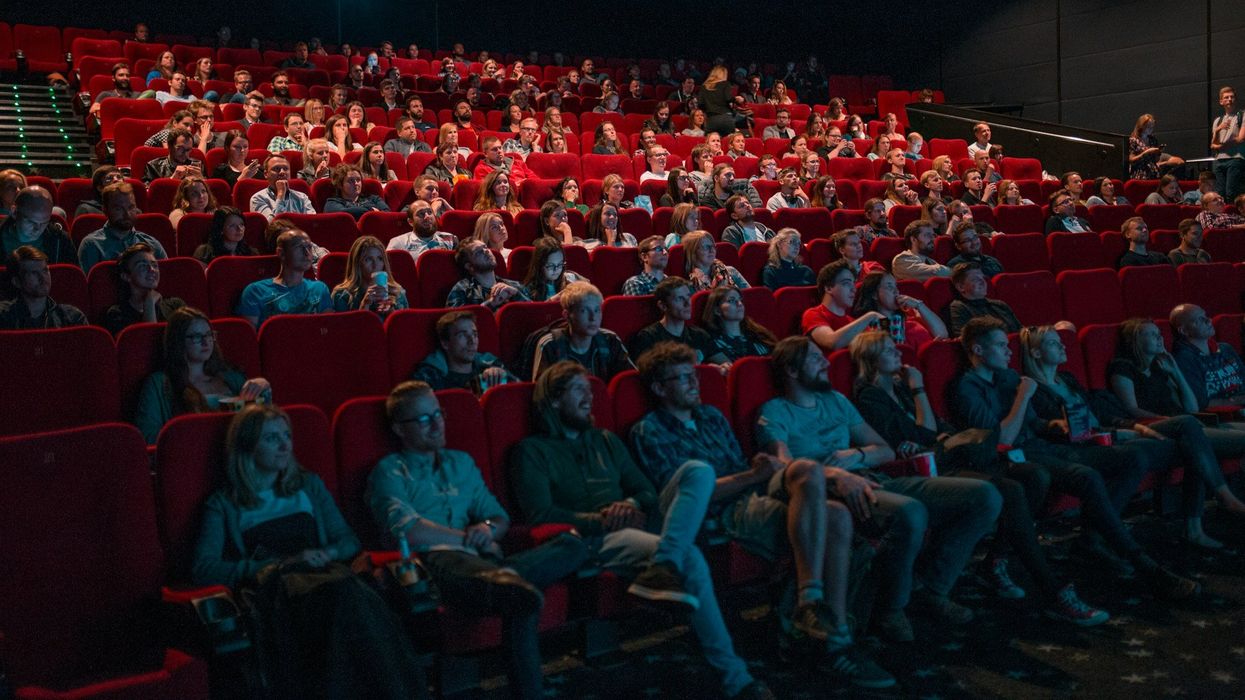 A movie theater full of people watch the screen