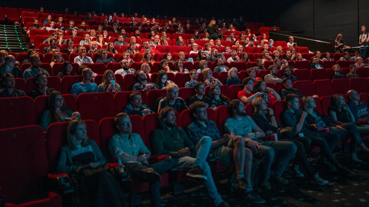 A movie theater full of people watch the screen