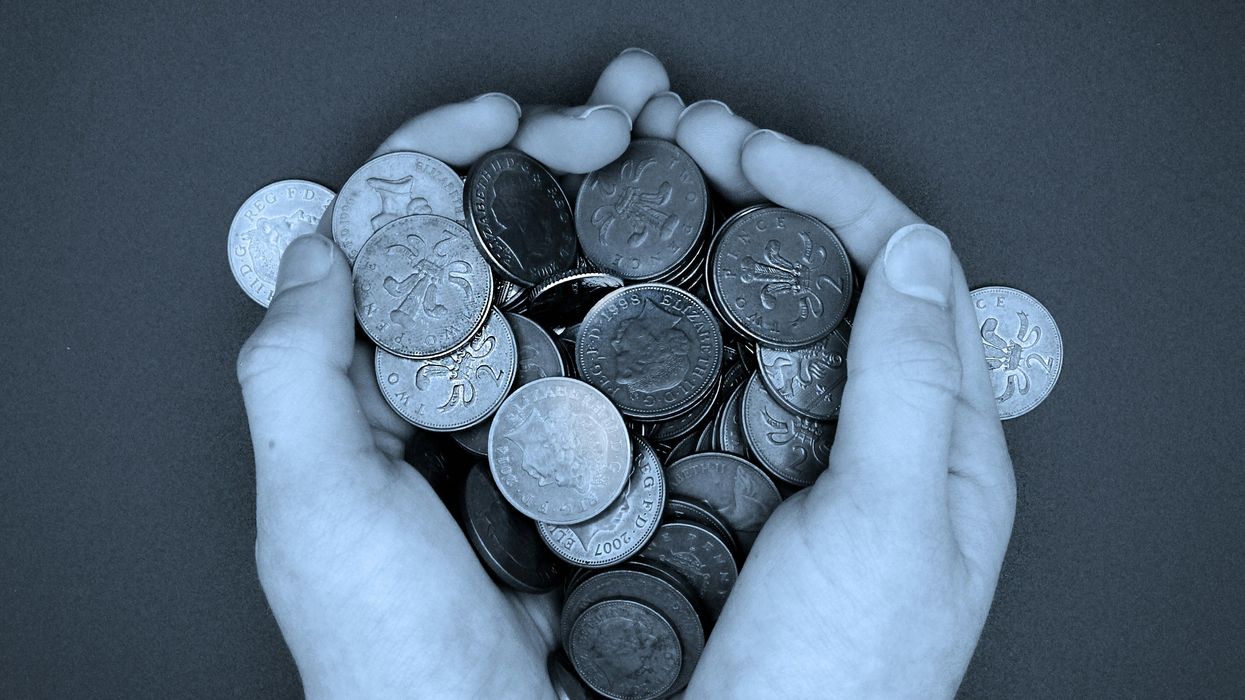 A pair of hands holding a pile of coins