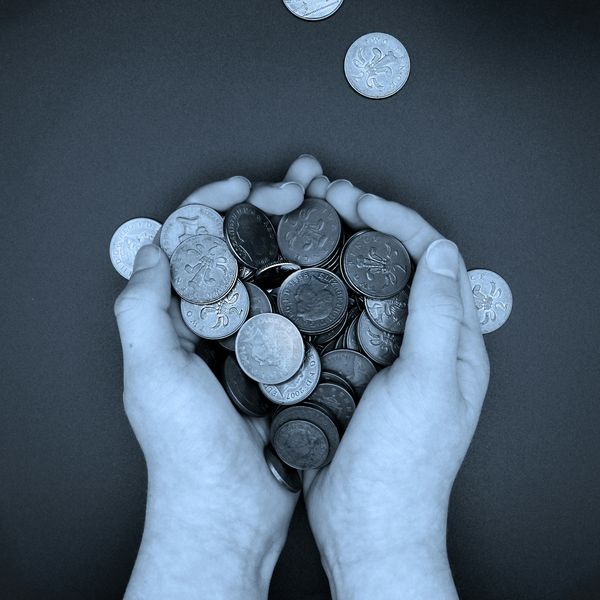 A pair of hands holding a pile of coins