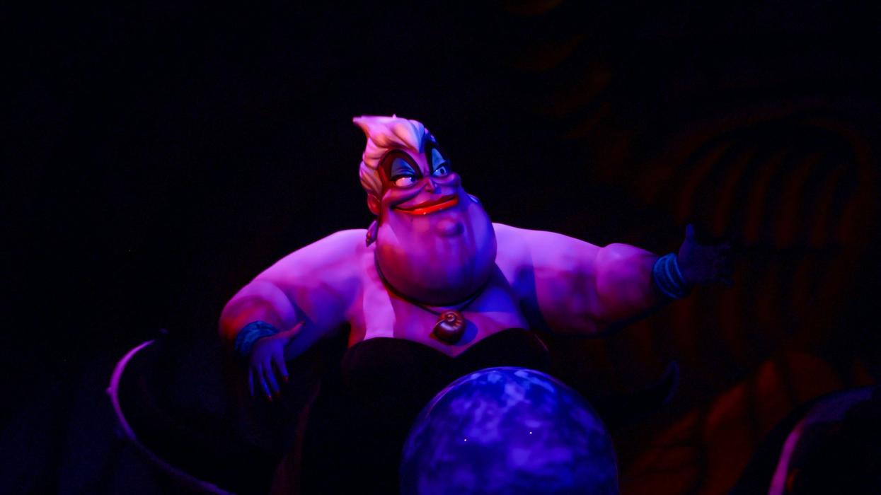 A photo of Ursula from "The Little Mermaid." She is smiling and floating against a black background.