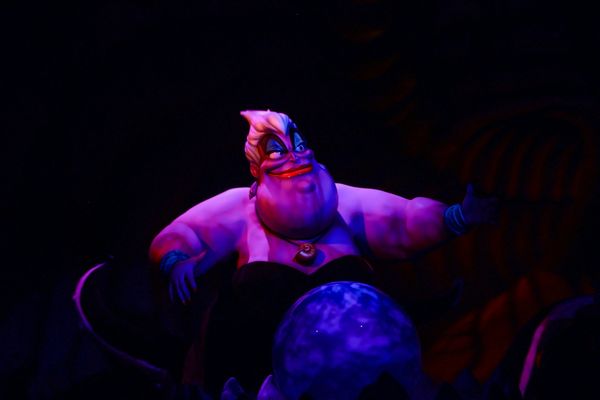 A photo of Ursula from "The Little Mermaid." She is smiling and floating against a black background.