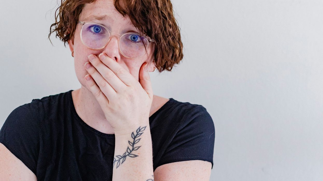 A red-headed woman covering her mouth