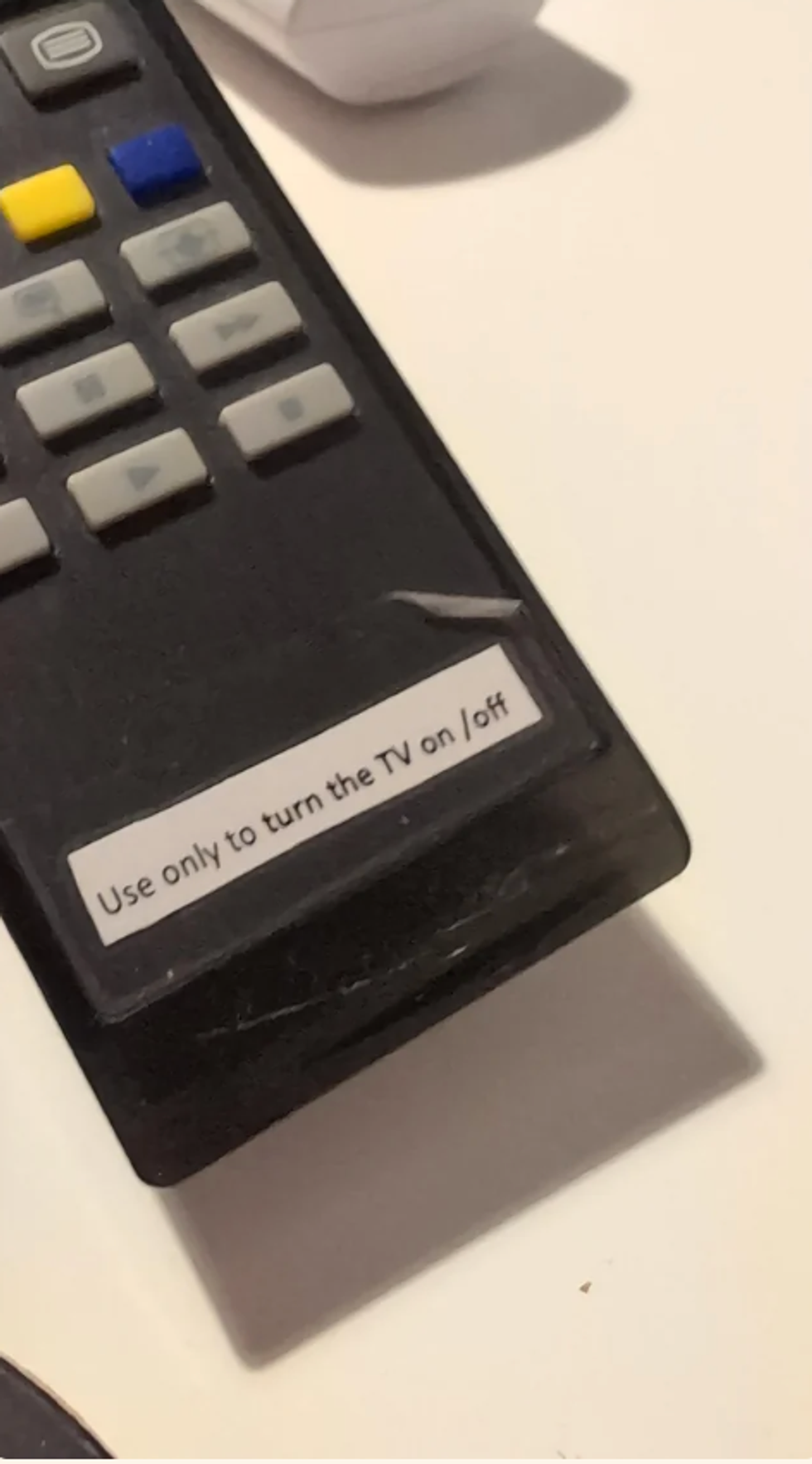 A remote control with a label saying "use only to turn the TV on/off at the bottom"