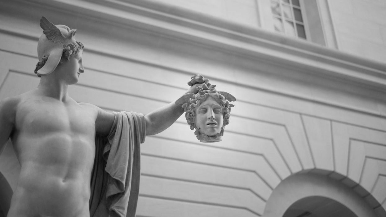 A Roman statue holds the head of another, in black and white