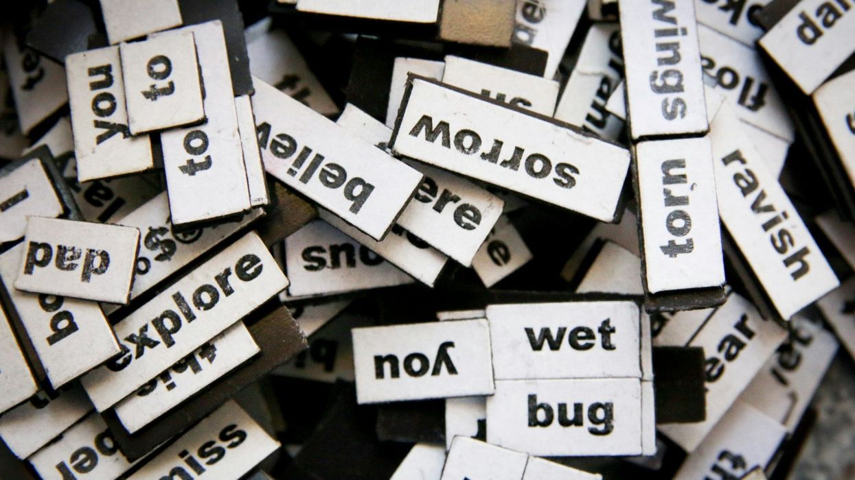 A shot of a ton of words typed out little magnets. They all sit in a messy bunch.