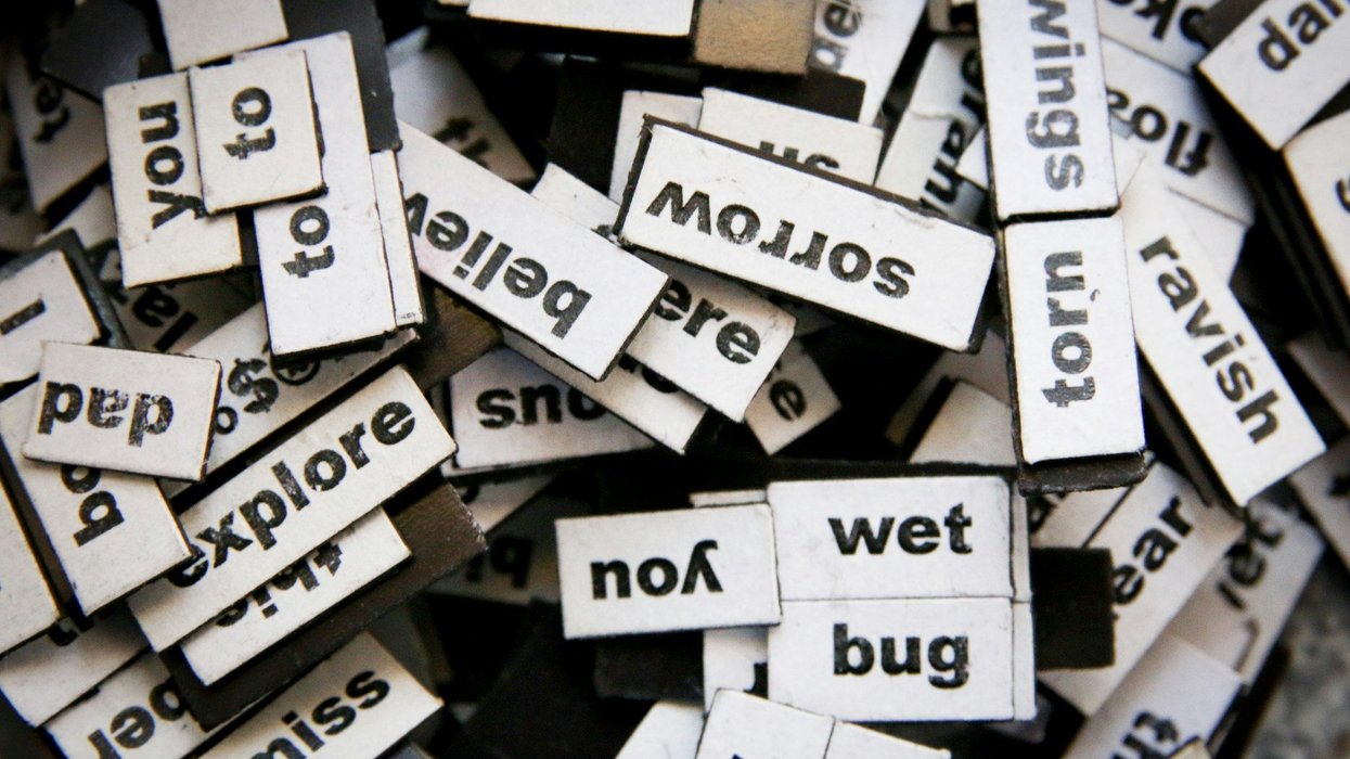 A shot of a ton of words typed out little magnets. They all sit in a messy bunch.