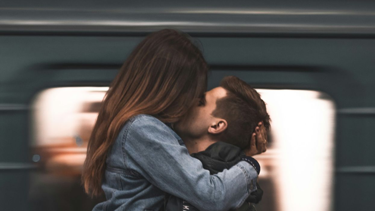 A woman and man kissing on the street