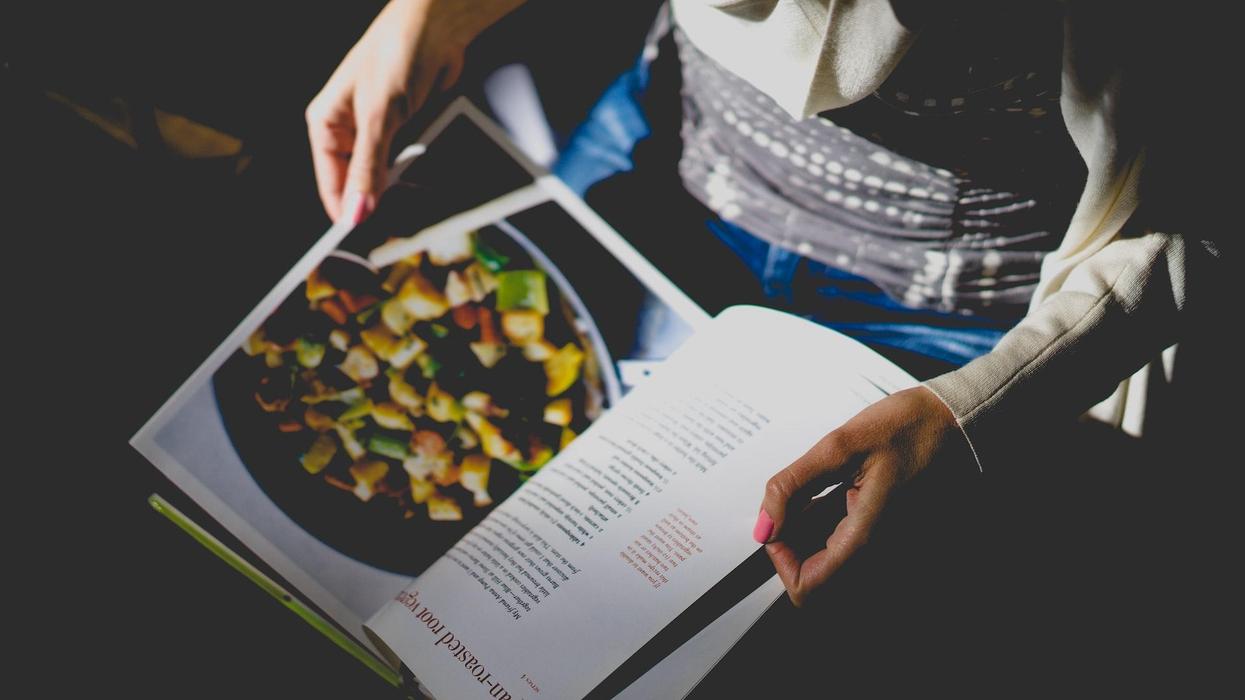 A woman flips through a recipe book