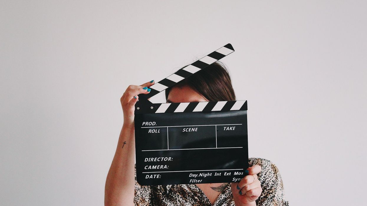A woman hides her face behind a slate.