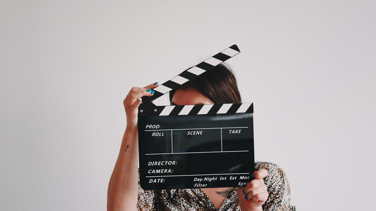 A woman hides her face behind a slate.