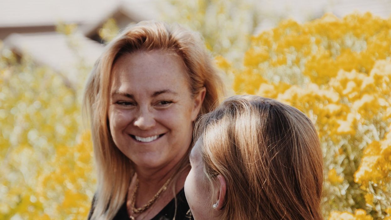 A woman in her 50's laughs with a younger girl