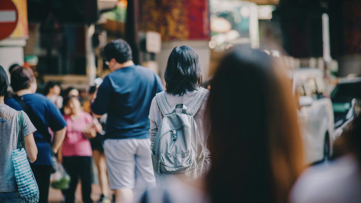 A woman looking at a group of people on a sidewalk