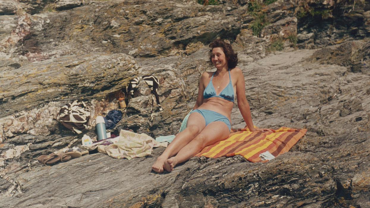 a woman sunbathing on rocks.