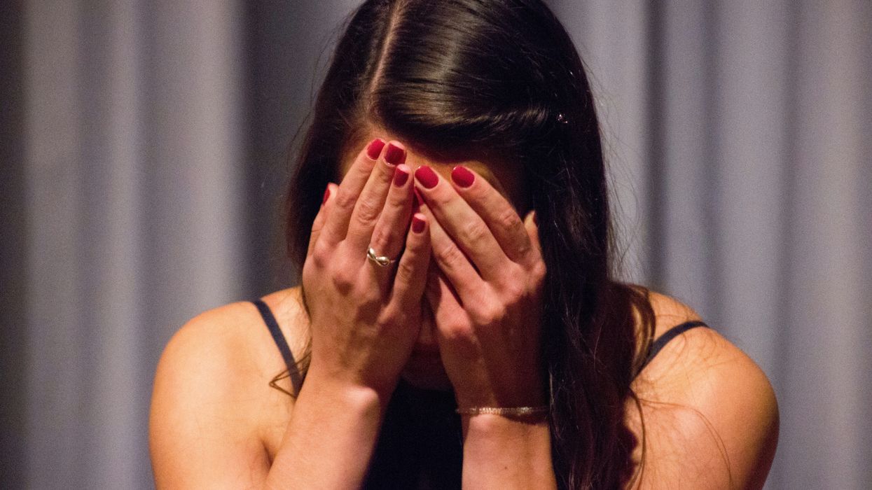 A woman with her head in her hands.