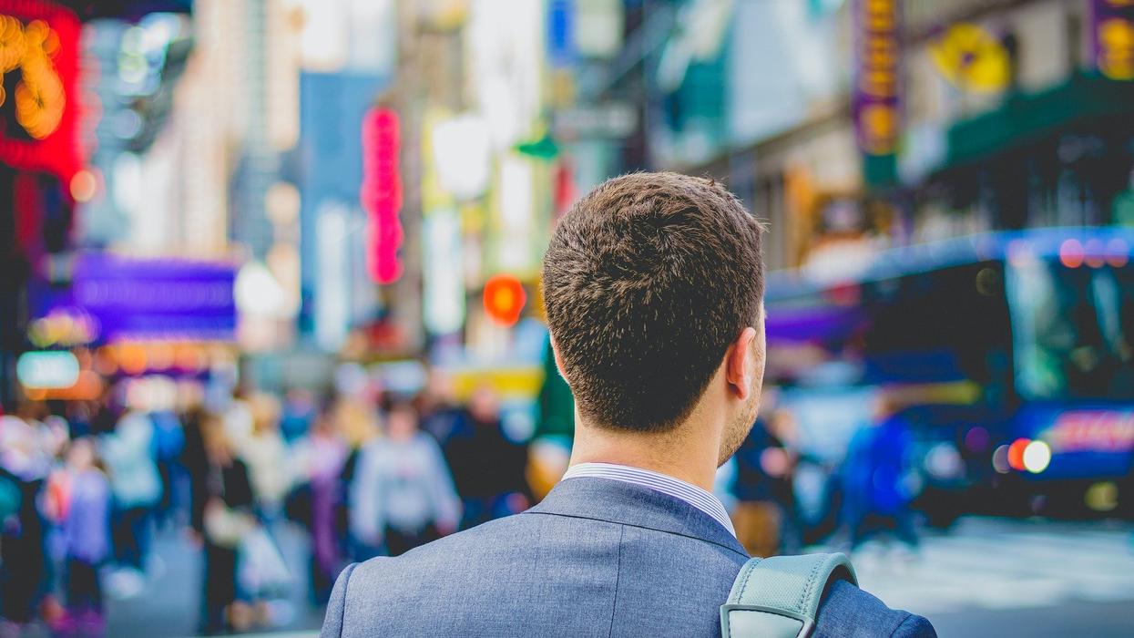 A young business man looks out into a city