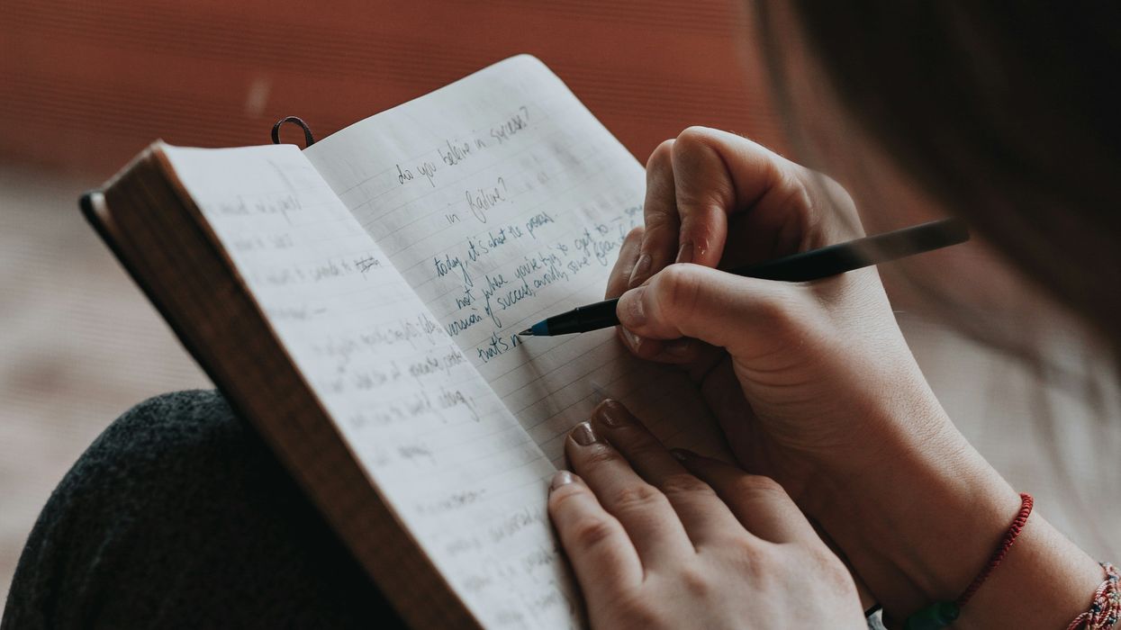 A young woman writing in a journal.