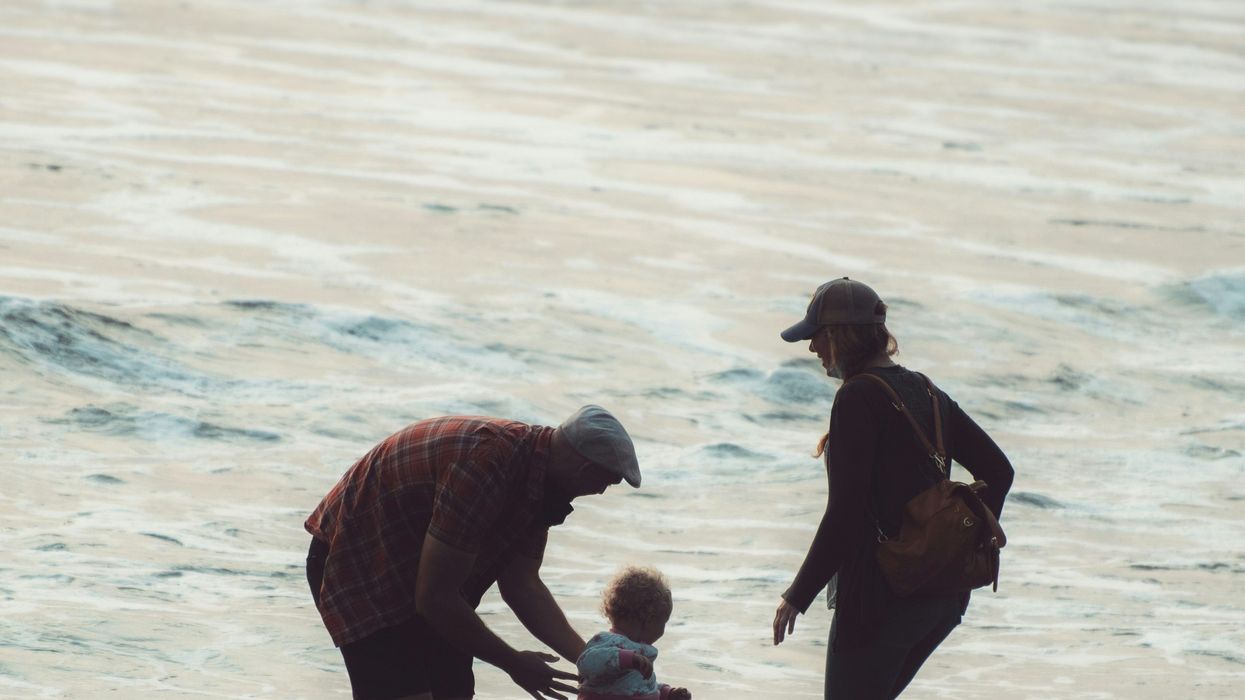adults with toddler on beach