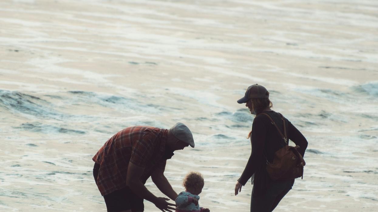 adults with toddler on beach