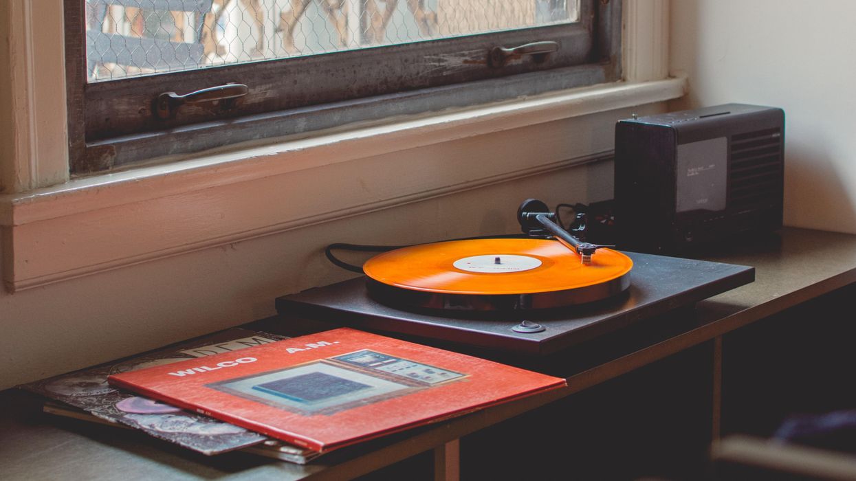 Album and turntable sitting beneath window