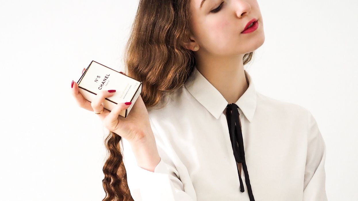 Aloof teen with high-end clothes and bottle of Chanel