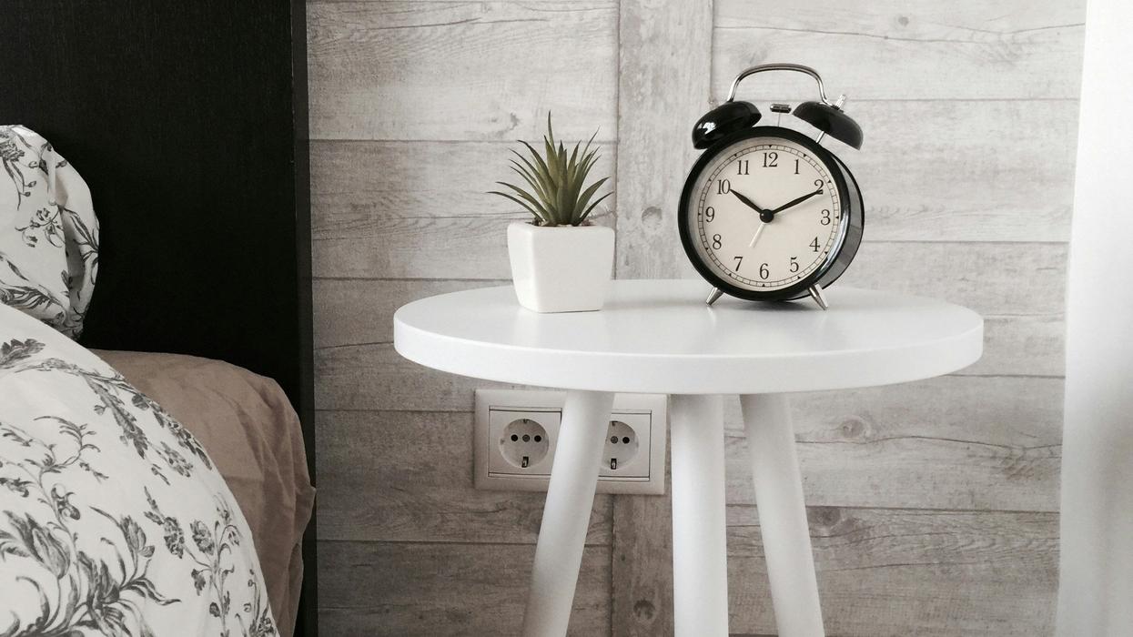 An Alarm clock sitting on a bedside table