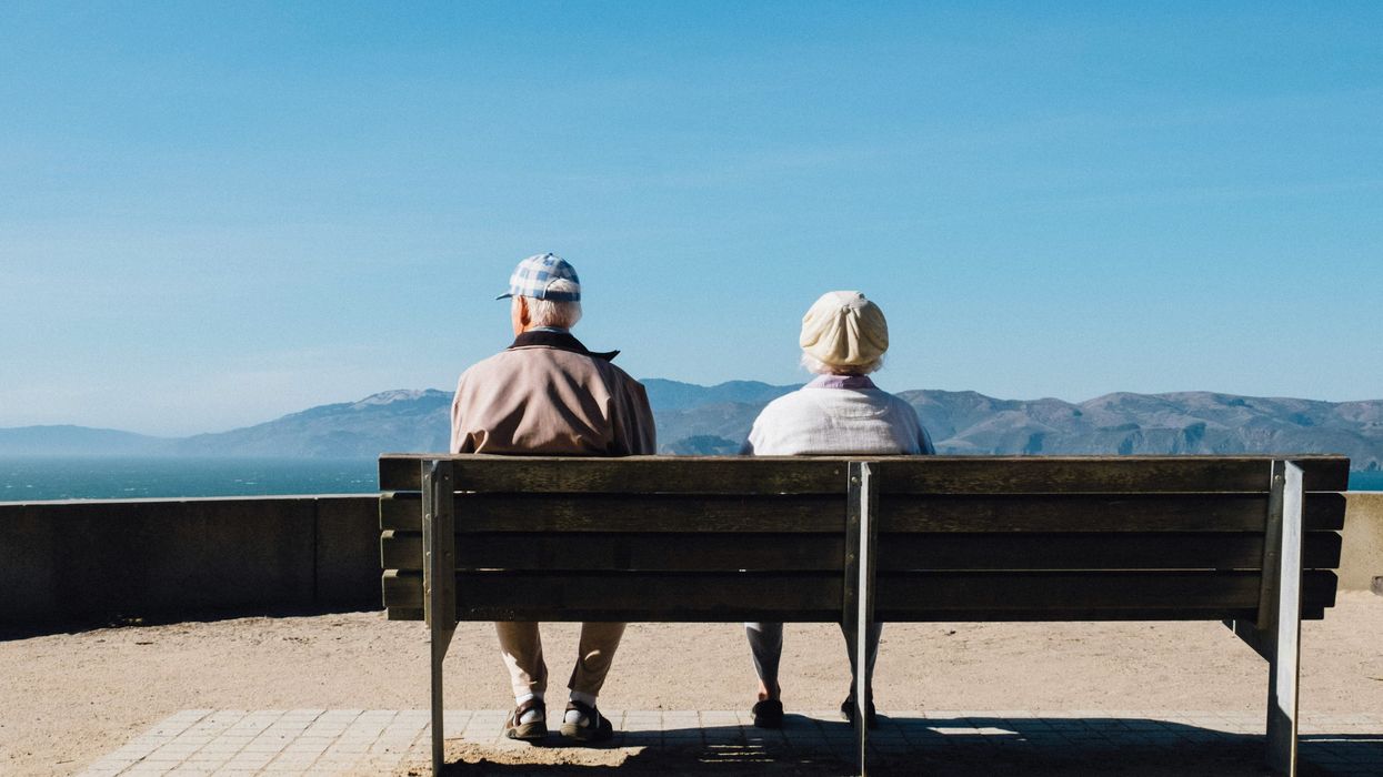 An elderly couple sitting on a bench