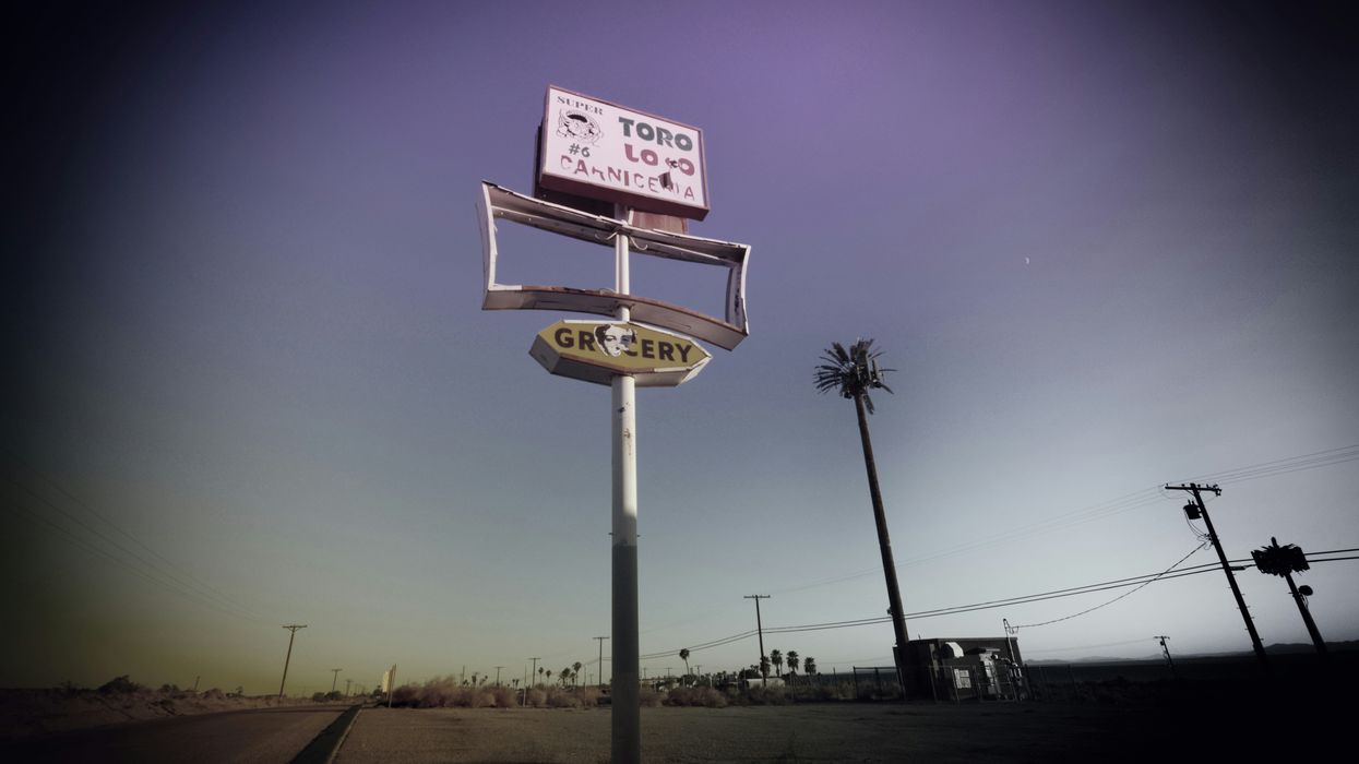 An empty storefront sign on a highway.